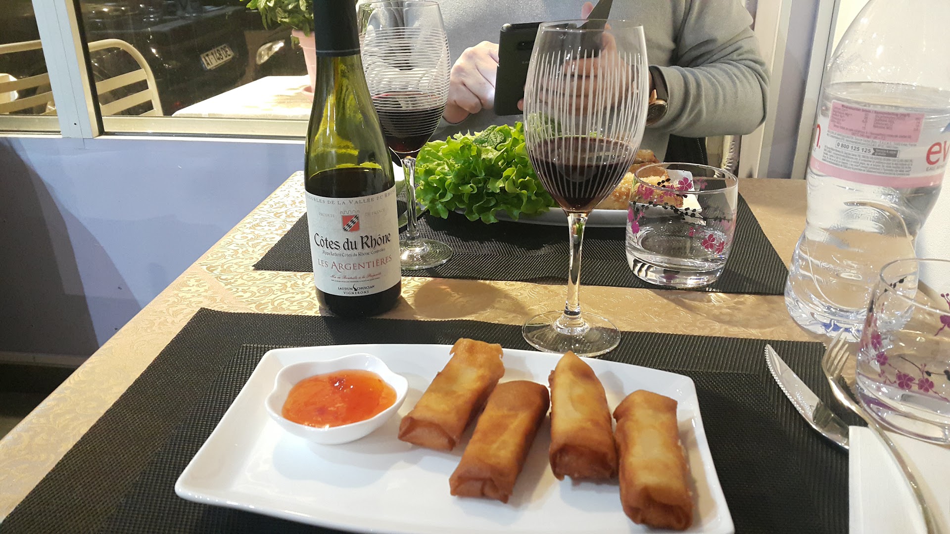 Une table avec des rouleaux, des verres et des plats à partager